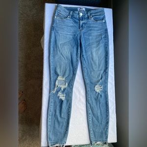 Distressed jeans with rips. White button size 26. Never been worn